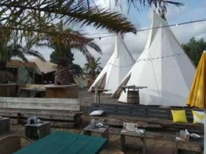 Twee imposante tipi tenten opgesteld bij Strandpaviljoen Oranje Buiten in Hoorn, prachtig gelegen aan het Markermeer voor een uniek en feestelijk evenement