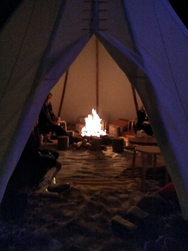 Gezellige tipi in de avond met kampvuur en accessoires in een indianentent