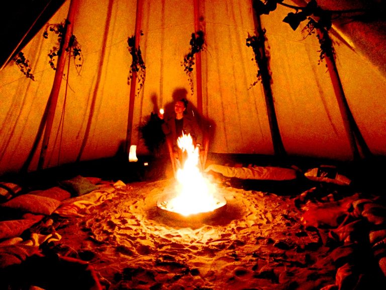 tipi-tent met een vuurtje in het midden op strand IJburg in Amsterdam