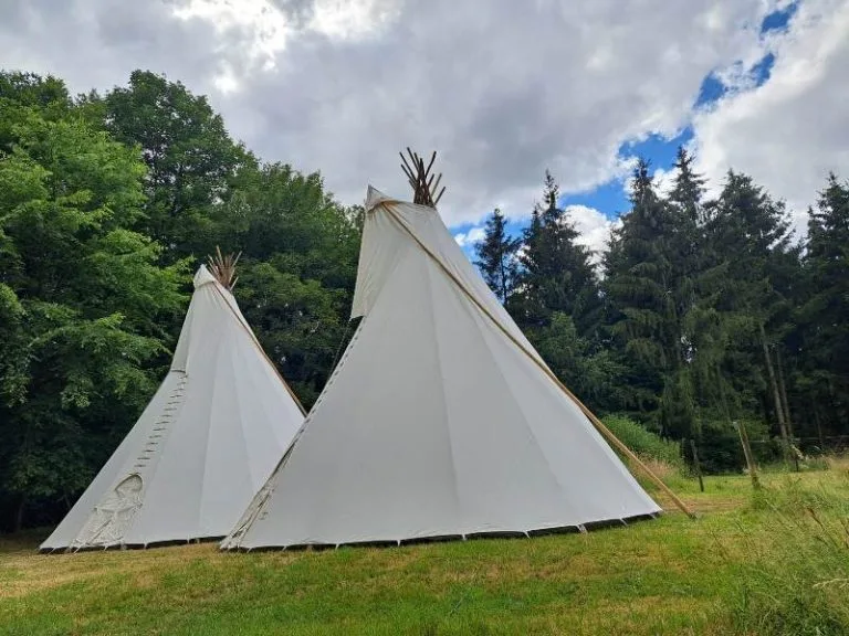 Twee sfeervolle tipi's op een grasveld in Brabant.