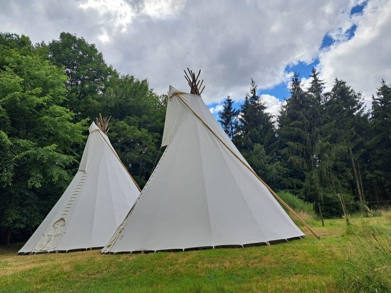Twee sfeervolle tipi's op een groen grasveld in Brabant.
