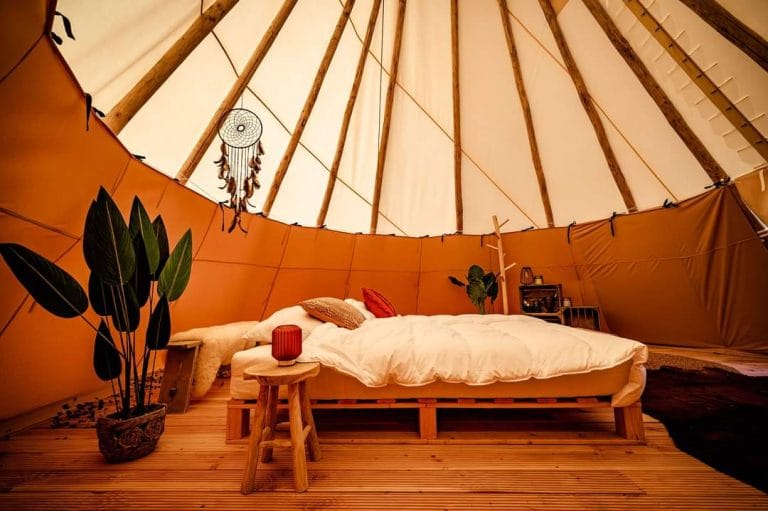 voorbeeld van een sfeervolle tipi-glampingtent met bed en andere inrichting