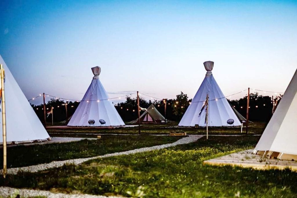 Sfeervolle tipi tenten in in de schemering voor tuin, glamping of evenement kopen geschikt voor tuin, events en overnachtingen