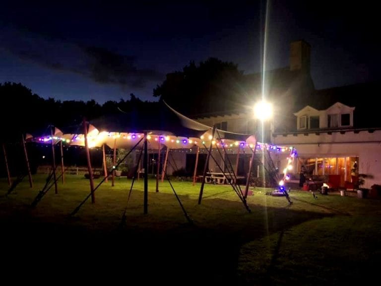 Kleurig verlichte stretchtent huren voor een sfeervol tuinfeest in Brabant - Windcirkeltenten