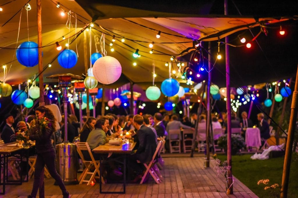Sfeervolle bruiloft onder een zandkleurige stretchtent bij de Snippenwei in Wieringerwerf, inclusief feestverlichting en decoratie van Windcirkeltenten